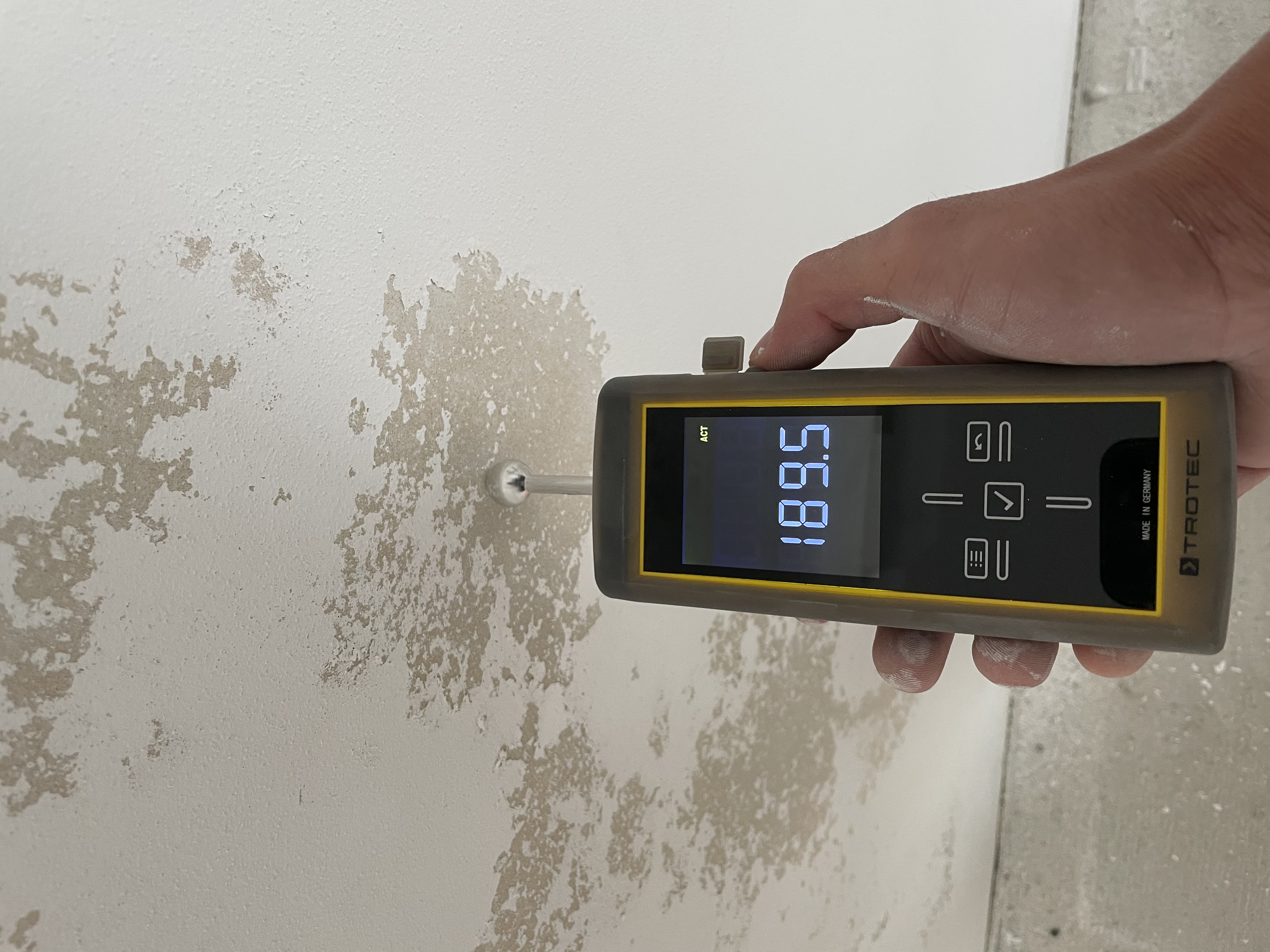 Feuchtigkeitsmessung an der Wand mit professionellem Messgerät vor Beginn der Arbeiten
