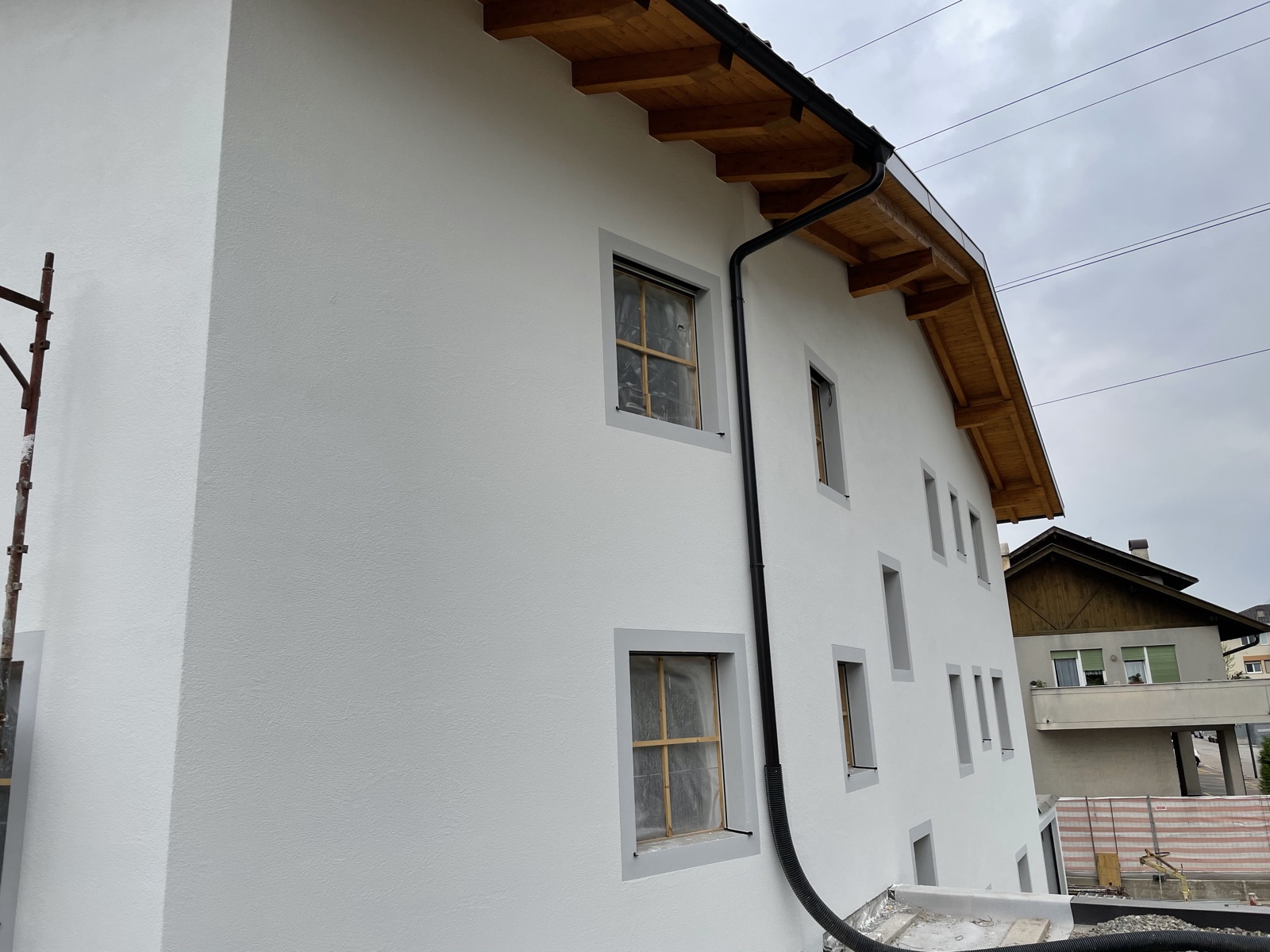 Wohnhaus in Eppan mit weißer Fassade und sichtbarem Holzdachstuhl