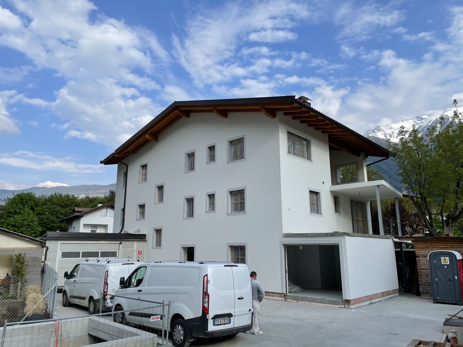 Mehrstöckiges Wohnhaus in Naturns mit weißer Fassade und grau abgesetzten Fensterrahmen