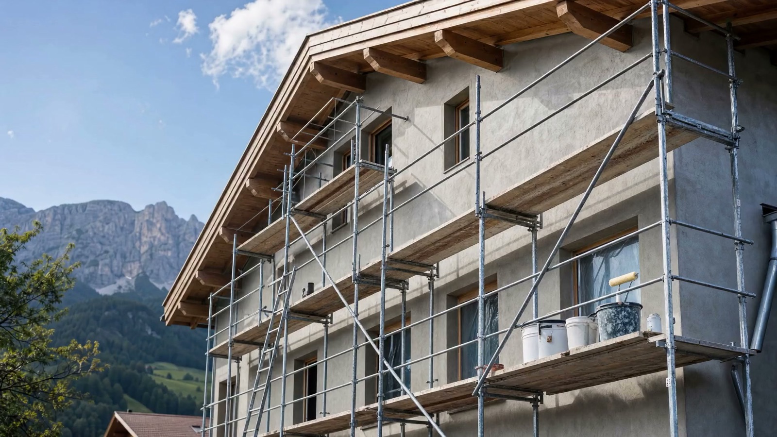 Eingerüstete, unverputzte Hausfassade in Südtirol vor Arbeitsbeginn