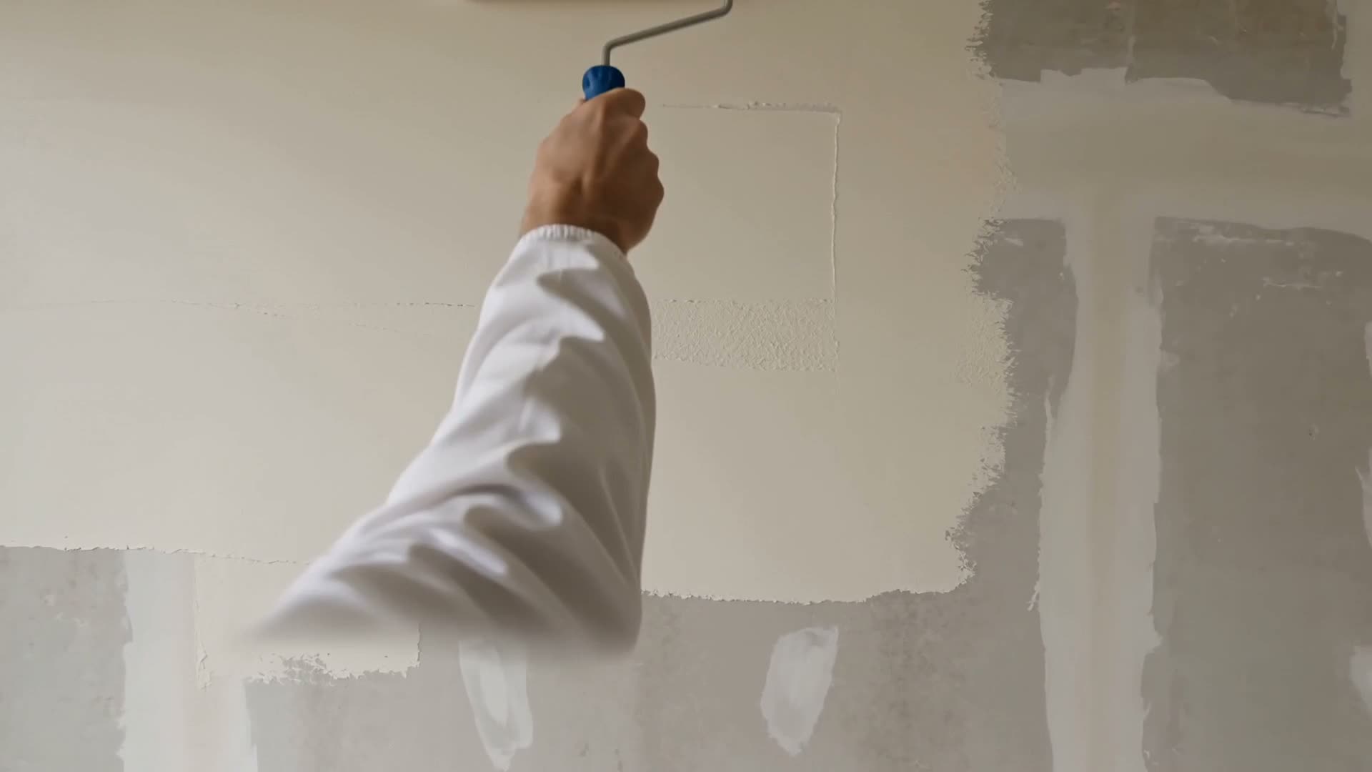 Maler bei der handwerklichen Bearbeitung der Wand mit dem Roller